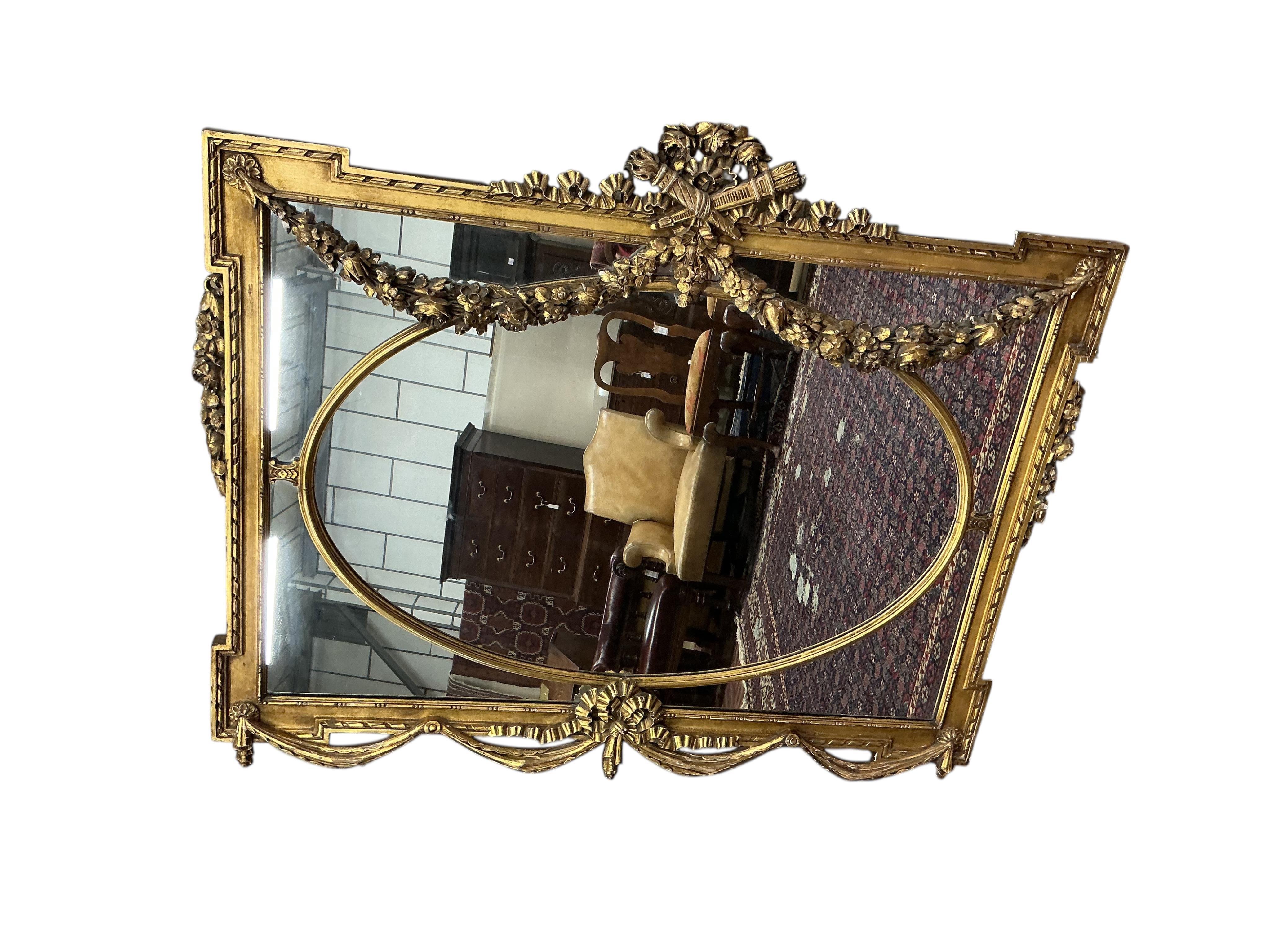 A Victorian style giltwood and composition overmantel mirror with cross torch and quiver crest, width 136cm, height 110cm
